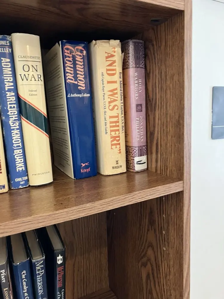 History books on a wooden shelf, including Clausewitz’s On War, Common Ground, “And I Was There” and Holy Warriors
