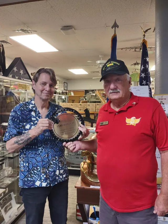 Tom Rinehart, Docent of the Military Museum, presenting an appreciation Bearing Circle to Curt Rowlett, Board of Director and IT of the museum