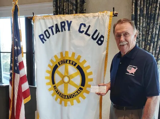 Joe McVay, director of the museum received check of $1,000 from Naples Pelican Bay Rotary Club