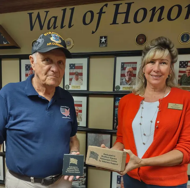 Docent, George presenting Memorial Paver to Helen, Concierge of Bradford Square