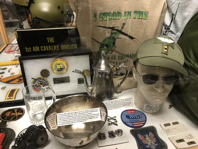 A display of 1st Air Cavalry Division patches, an officer’s cap, sunglasses and a silver bowl and pitcher