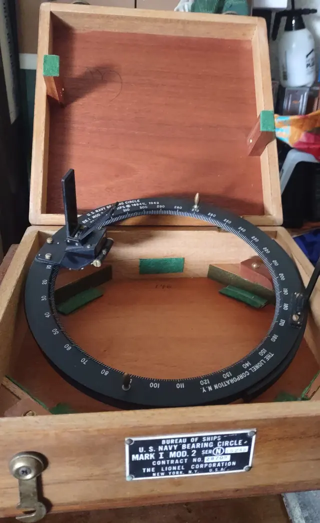 A brass bearing circle in an open wooden box